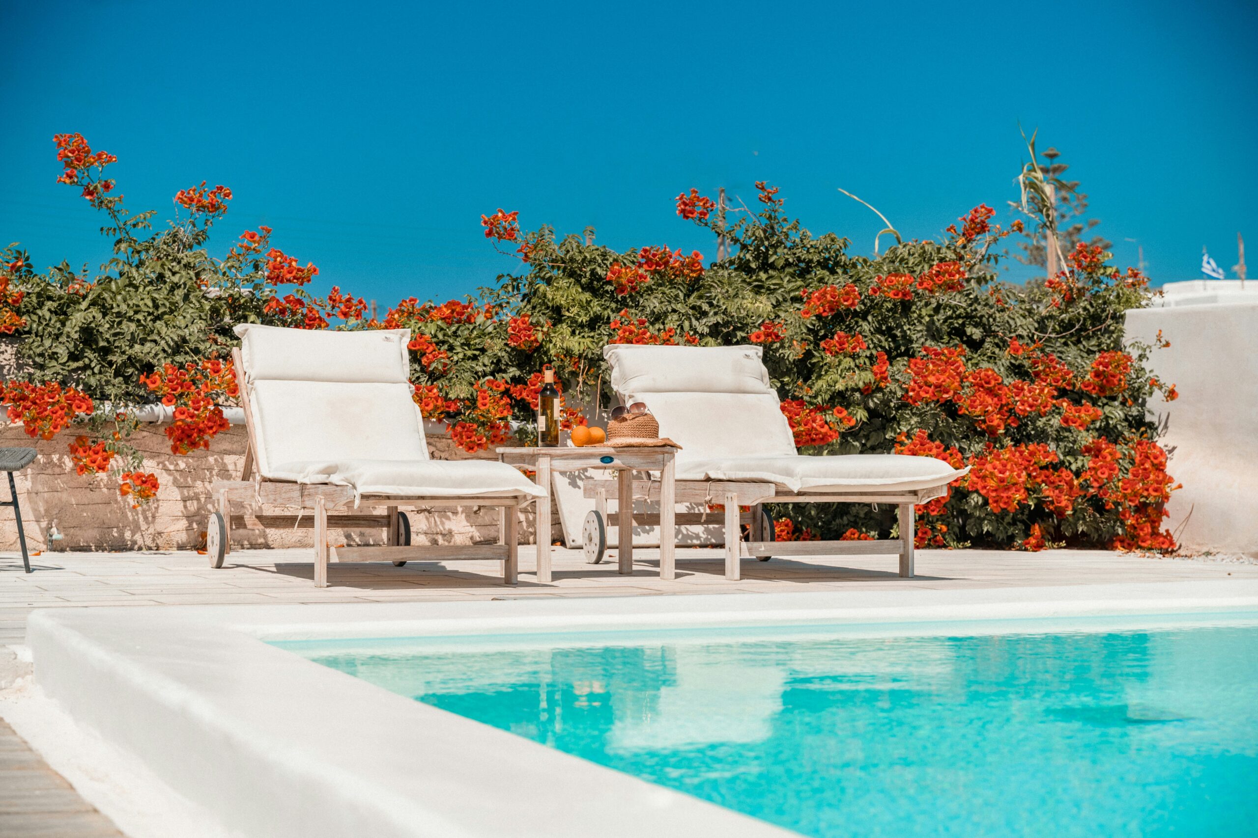 two chairs by a pool and red flowers | carlisledigitalmarketing.com