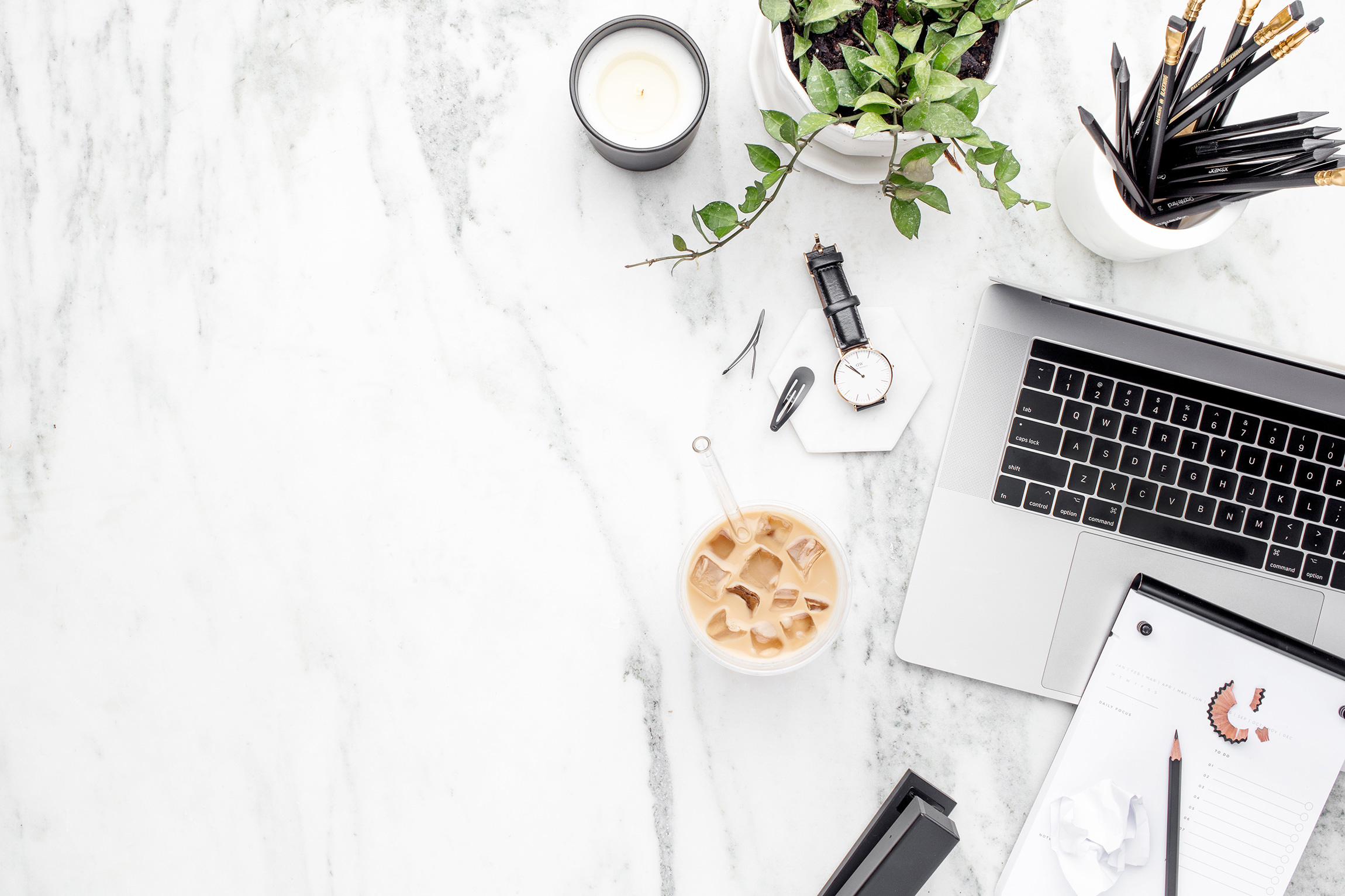 desk with laptop, notepad, plant, and iced coffee | carlisledigitalmarketing.com