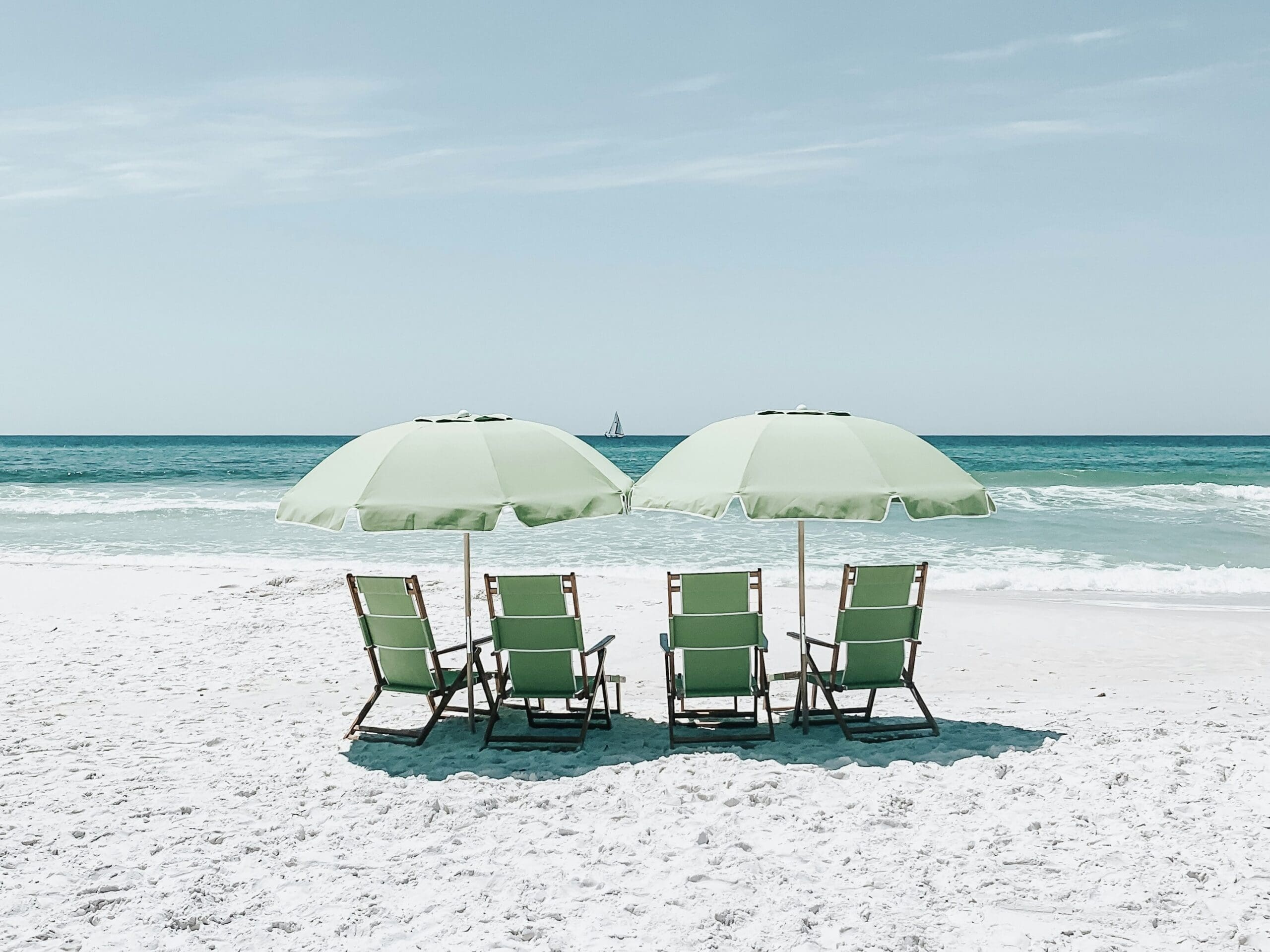 four beach chairs and two umbrellas